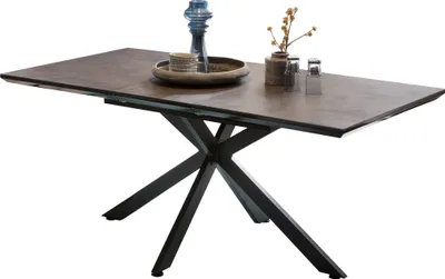 A dining table with a dark brown ceramic-look top and a black metal base.