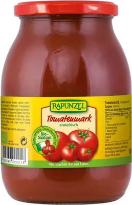 A glass jar of tomato paste with a label.