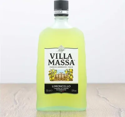 A bottle of Limoncello Villa Massa on a wooden surface.