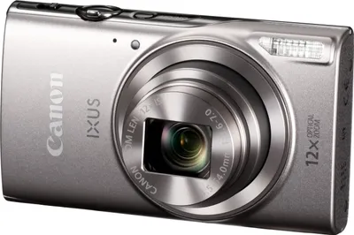 A silver Canon IXUS compact camera is shown from a diagonal front view against a white background.