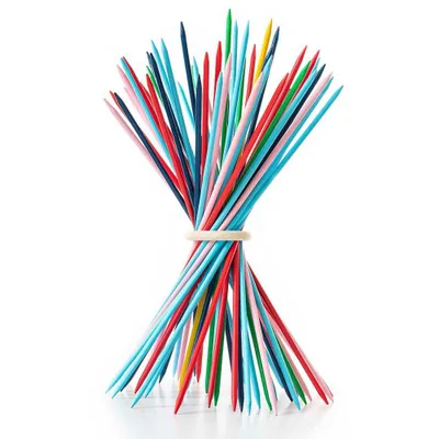 A bundle of colorful Mikado sticks, held together by a rubber band, standing upright on a white surface.
