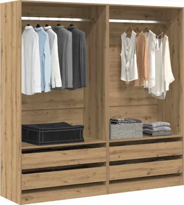 Interior view of a wooden wardrobe with clothes hanging and storage boxes.