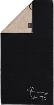 A black and beige towel is folded and displayed against a white background. A small embroidered dachshund is visible on the black side of the towel.