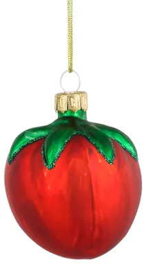 Ein glänzender Weihnachtsbaumanhänger aus Glas in Form einer roten Tomate mit grünem Strunk vor weißem Hintergrund.