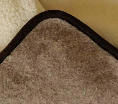 A close-up view of the corner of a blanket, showing the texture of the fabric and the binding.