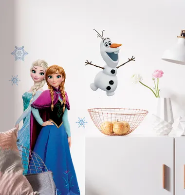 A wall decorated with Frozen-themed stickers, including characters Anna and Elsa, and Olaf the snowman. A decorative basket with apples and a vase with flowers are on a shelf below.
