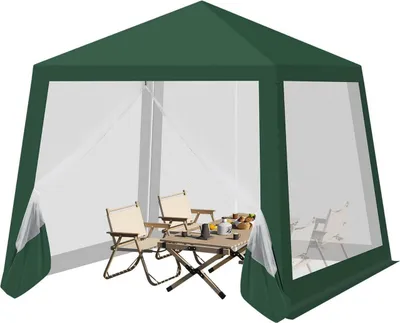 A green gazebo with mosquito netting, set up with a table and chairs inside.