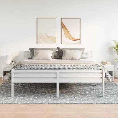 A bedroom scene with a white bed frame, pillows, a blanket, and two nightstands.