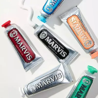 A collection of Marvis toothpaste tubes arranged on a white surface.