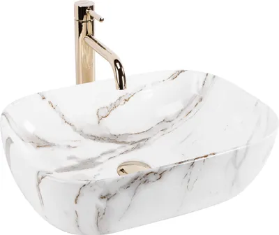 A white oval vessel sink with a marble-like pattern and a gold faucet.