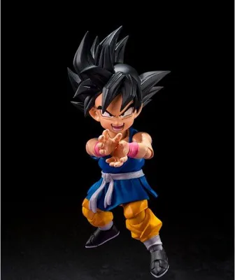 A figurine of a cartoon character with black spiky hair, wearing a blue tunic and yellow pants, with its hands held up in front of its chest.