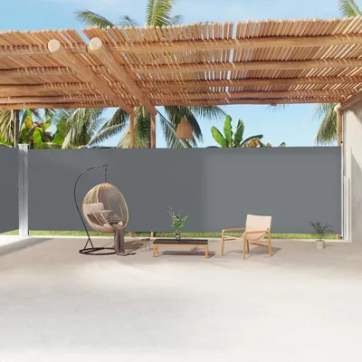 An outdoor patio area with a retractable side awning, a hanging chair, and a small coffee table.