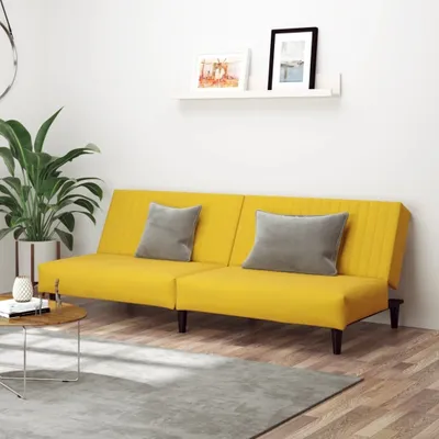 A yellow sofa with two gray cushions in a room with a plant and a shelf with pictures.