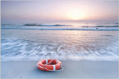Produktbild von Wallario Wandbild Rettungsring am Strand bei Sonnenuntergang, Größe: 61 x 91,5 cm, Poster mit rahmenlosen Bildhalter