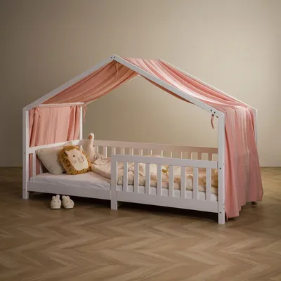 A child's bed with a pink canopy and bedding, including a lion-shaped pillow.