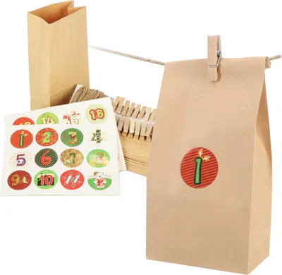 A collection of brown paper bags, clothespins, and numbered stickers for creating a DIY advent calendar.