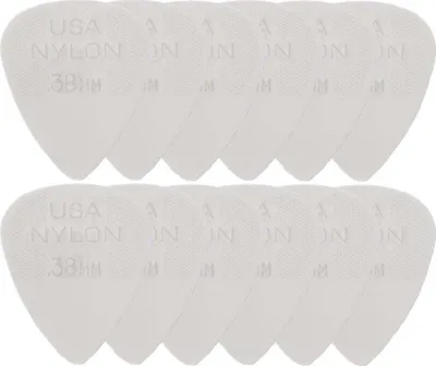 A top-down view of multiple white guitar picks arranged in two rows.