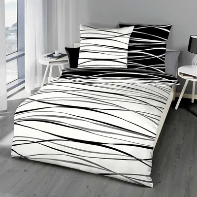 A bed with black and white striped bedding is shown in a room with a window and a side table.
