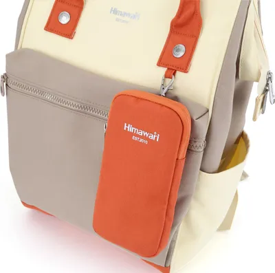 A close-up view of a backpack with a small orange pouch attached.