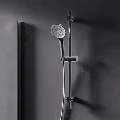 A modern shower head and rail set mounted on a dark gray wall.