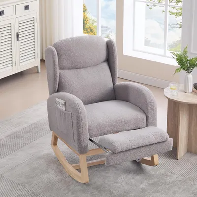 A gray rocking chair with an extended footrest is shown in a well-lit room with a window and a side table.
