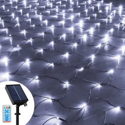 A net of white LED lights spread across a wooden floor, with a solar panel and remote control in the foreground.