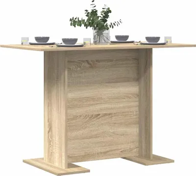 A dining table set with bowls and glasses, with a vase of greenery on top.