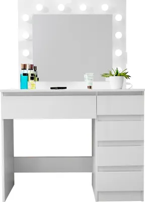 A white vanity table with a mirror and lights, displaying some cosmetic products.