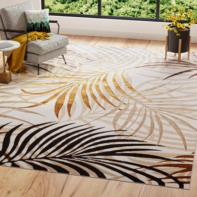A rug with a palm leaf pattern is laid out on a wooden floor in a living room setting, next to a chair and a window.