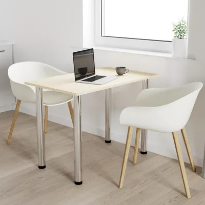 A table and chairs in a room with a window.