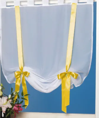 A white sheer curtain with yellow ribbons tied into bows.