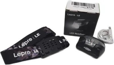A product shot of a headlamp and its accessories, including the packaging.