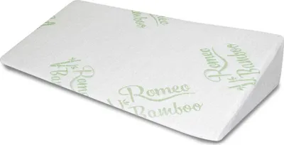 A wedge-shaped pillow with a white cover and green text.