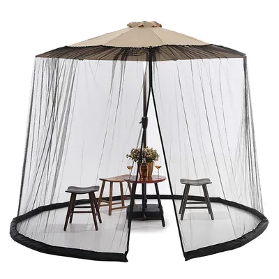 A mosquito net enclosure for a patio umbrella, set up around a small table and chairs.