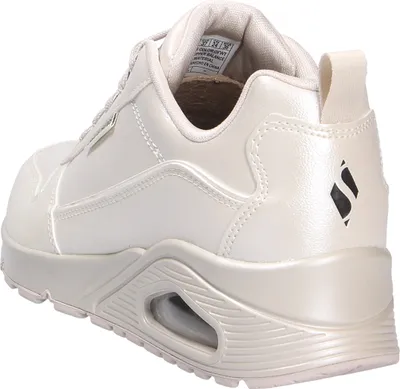 A side view of a beige Skechers sneaker.