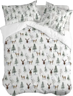 A duvet cover and pillowcases with a winter forest and deer pattern, laid out flat.