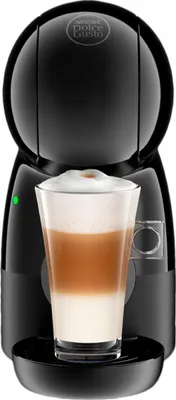 A black Dolce Gusto coffee machine with a glass of latte macchiato in front of it.