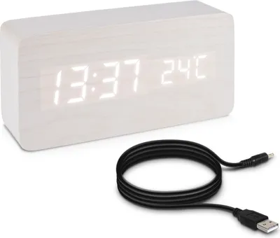 A digital alarm clock with a wood-look finish and a USB cable.