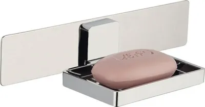 A polished metal soap dish with a bar of pink soap, attached to a metal plate mounted on a wall.