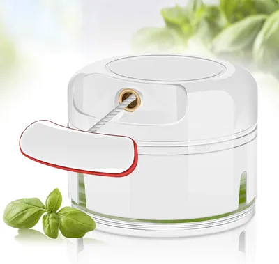 A manual onion chopper with a pull cord, shown with basil leaves in the foreground.