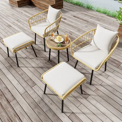 A patio set with two chairs, two ottomans, and a small table on a wooden deck.