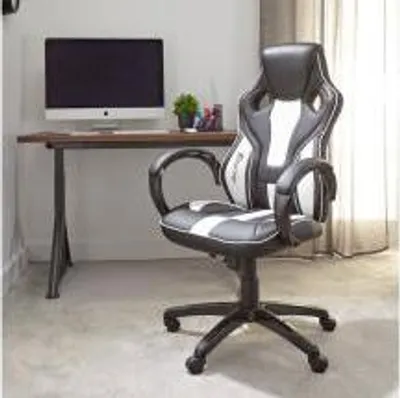 A gaming chair is positioned next to a desk with a computer.