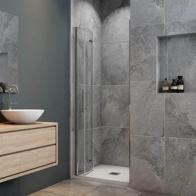 A modern bathroom with a sink, vanity, and shower enclosure.