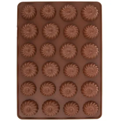 A top-down view of a brown silicone baking mold filled with chocolate candies.
