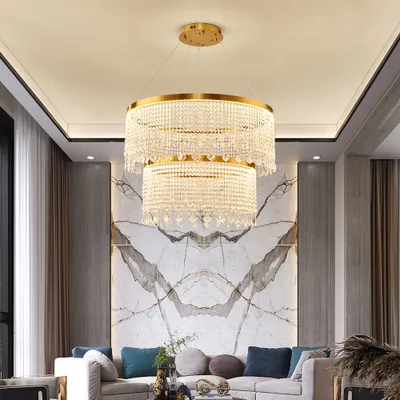 A luxurious living room with a large marble accent wall and a modern, multi-tiered crystal chandelier.