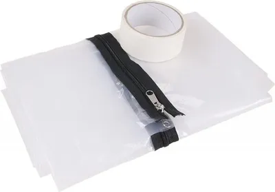 A roll of white tape and a black zipper are placed on top of a folded white plastic sheet.