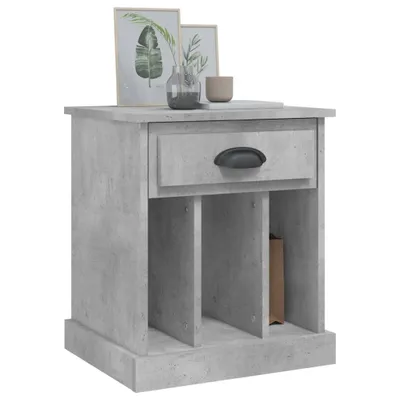 A bedside table with a drawer and open shelves, decorated with framed pictures and a vase on top.