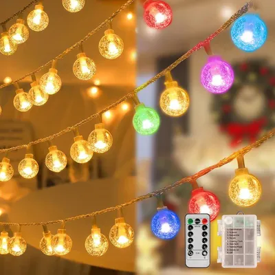A string of fairy lights with round, textured bulbs in various colors, some warm white and others colored, displayed in a split image showing both indoor and outdoor settings. A remote control and battery pack are also visible.