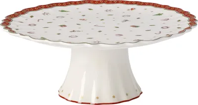 A white cake stand with a decorative rim and scattered festive motifs.