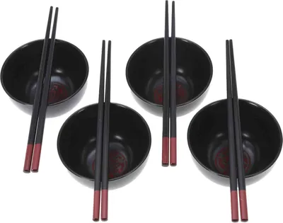 Four black ceramic bowls with chopsticks on a white background.